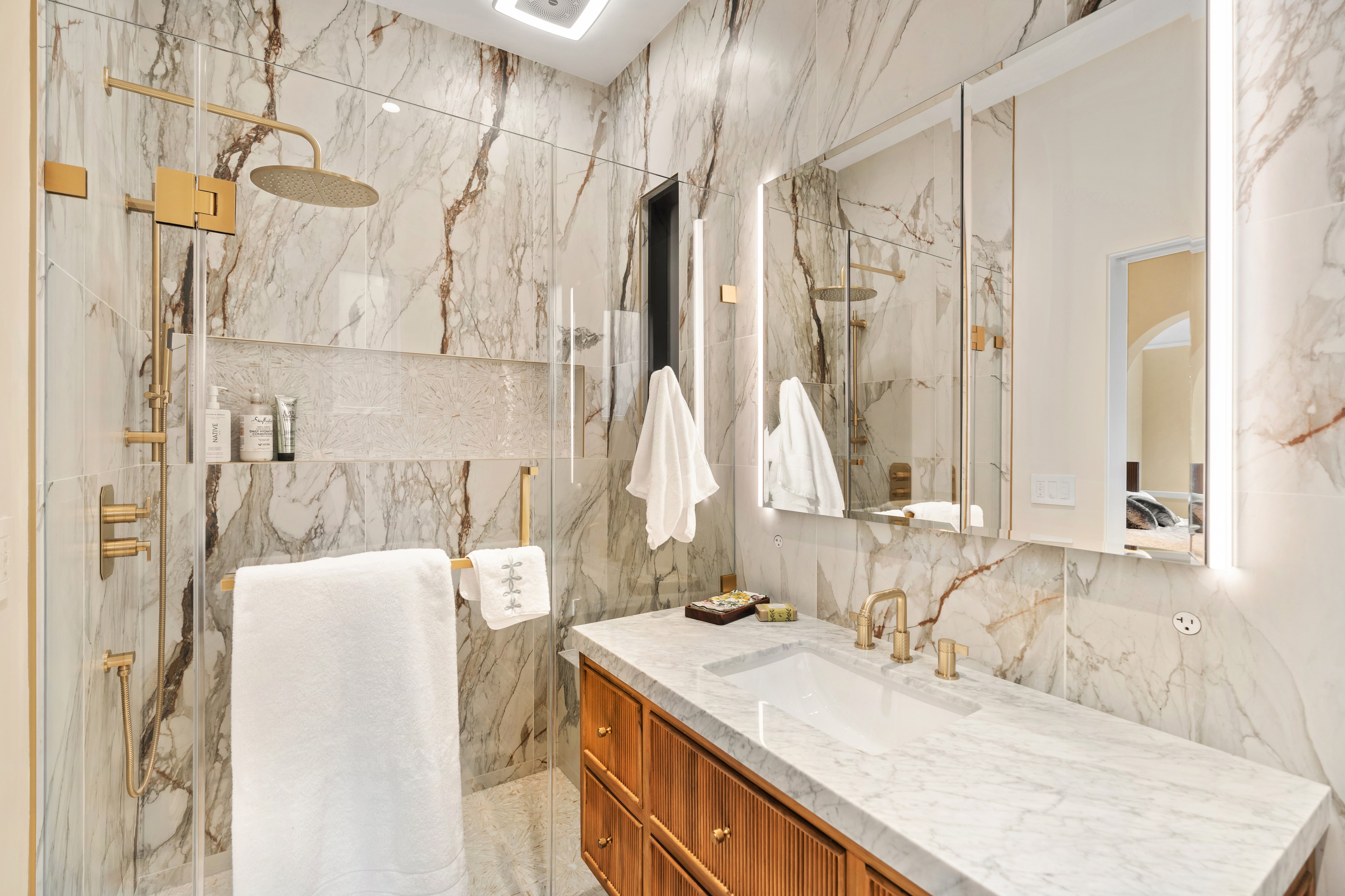 White subway tile shower with brass fixtures and rain head